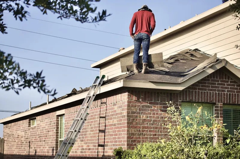 Professional roofer working on a residential roof in Atwood